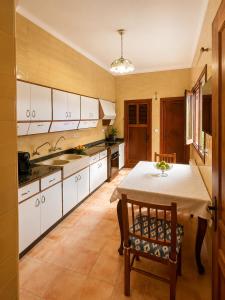 a kitchen with a table and a kitchen with white cabinets at Sa Torre - Casa Mallorquina con encanto in Campos +7 photos