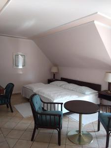 a bedroom with a bed and a table and chairs at Castelinho Apartmanház in Gyenesdiás