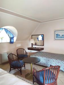 a bedroom with a bed and a table and chairs at Castelinho Apartmanház in Gyenesdiás