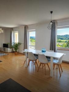 a dining room with a white table and chairs at Halna Residence in Krynica Zdrój