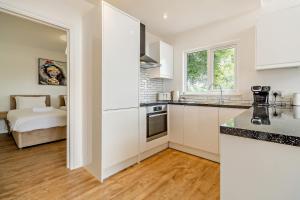 a kitchen with white cabinets and a bed in the background at Host & Stay - Robin Lodge in Belton +10 photos
