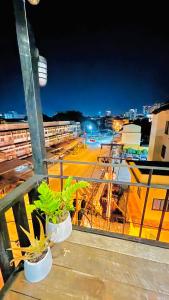 a balcony with two potted plants on a building at The Yak Cozy Chiang Mai in Chiang Mai