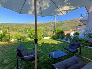 a patio with two chairs and an umbrella at Serra Viva in Cortes do Meio
