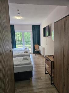 a hotel room with two beds and a desk at JURAJSKI OLSZTYN in Olsztyn