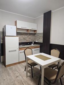 a kitchen with a table and a white refrigerator at JURAJSKI OLSZTYN in Olsztyn