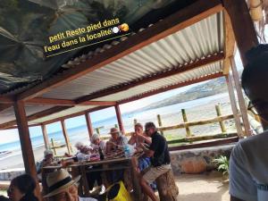 a group of people sitting at a bar at the beach at Le Toit Enchanté in Port Mathurin