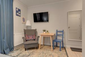 a living room with a chair and a table and a tv at WaterLane Island Hostel&Apartments in Gdańsk