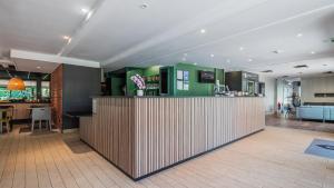 a bar in a room with a kitchen and a living room at Campanile NATURE - Colmar Parc des Exposition in Colmar
