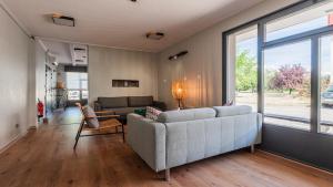 a living room with a couch and a large window at Campanile NATURE - Colmar Parc des Exposition in Colmar