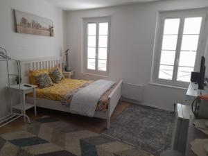 a bedroom with a bed and two windows at S C I TREFLe in Vernon