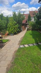 a brick walkway in a yard with grass and buildings at Pfälzerblick Lambrecht- Ferienwohnung mit Garten in Lambrecht