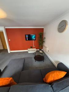 a living room with a couch and a flat screen tv at Aphrodite in Birmingham