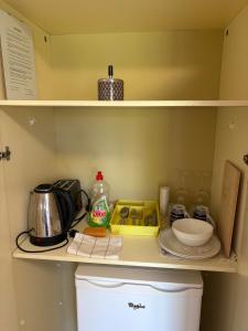 a kitchen with a shelf with various items on it at Apartments & Rooms Ribarić in Lovran
