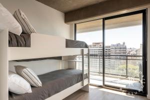 a bedroom with bunk beds with a large window at Top Rentals Nuñez in Buenos Aires +24 photos