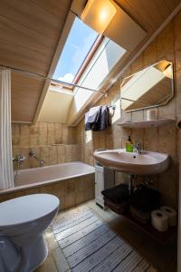 a bathroom with a sink and a toilet and a window at Ferienwohnung Kampenwand in Bad Endorf