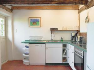 a kitchen with white cabinets and a green counter top at Ferienwohnung Hasenkate I - Boldevitzer Rügenkaten in Parchtitz