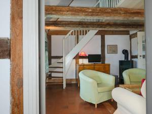 a living room with two chairs and a staircase at Ferienwohnung Hasenkate I - Boldevitzer Rügenkaten in Parchtitz