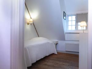 a white bedroom with a bed and a window at Ferienwohnung Hasenkate I - Boldevitzer Rügenkaten in Parchtitz