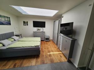 a bedroom with a bed and a flat screen tv at Apartment am Rathaus in Heimbach