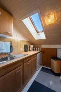 a kitchen with a sink and a skylight at Ferienwohnung Kampenwand in Bad Endorf +13 photos