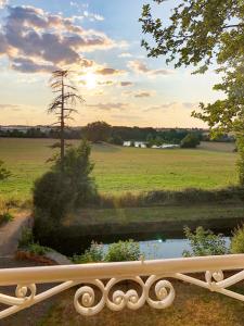 a bridge over a pond with a field in the background at Château de la Tourlandry in Chemillé