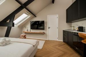 a bedroom with a bed and a kitchen with a window at Leeuwenhof Suites in Antwerp