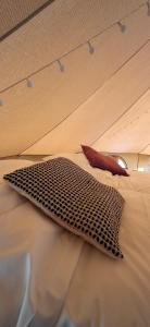 a bed with a pillow on top of it at Tente équipée in Waimes