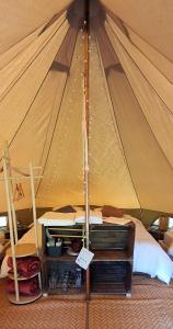 a tent with a bed and a table in it at Tente équipée in Waimes