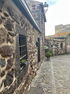 a stone building with a window with flowers in it at Prendas Paulilatino in Paulilatino