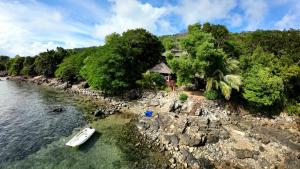 a boat in the water next to a rocky shore at Manta be à Nosy Komba in Ampangorinana