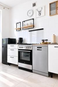 a kitchen with a stove and a refrigerator at Apartament BIELSKA 26 in Płock +6 photos