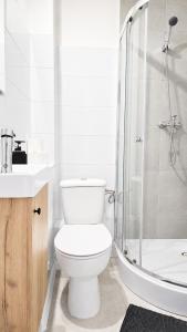 a white bathroom with a toilet and a shower at Apartament BIELSKA 26 in Płock