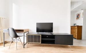 a living room with a black entertainment center with a television at Apartament BIELSKA 26 in Płock