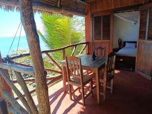 a wooden table and chairs in a room with a view of the ocean at Manta be à Nosy Komba in Ampangorinana +6 photos