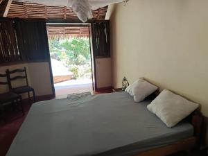 a bedroom with a bed with two pillows on it at Manta be à Nosy Komba in Ampangorinana
