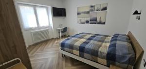 a bedroom with a bed and a window and a desk at Drago 48 in Oltre il Colle