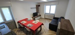 a small living room with a red table and chairs at Drago 48 in Oltre il Colle