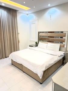 a bedroom with a large bed with white sheets at شاليهات حياة روز in Taif +14 photos