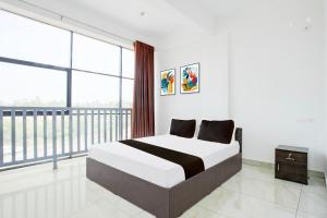 a bedroom with a bed and a large window at Hotel O D'Rooms in Trivandrum