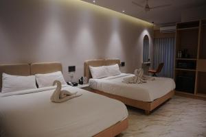 ein Hotelzimmer mit zwei Betten, auf denen Handtücher liegen in der Unterkunft Hotel Shellmark in Elivāla + 17 Fotos