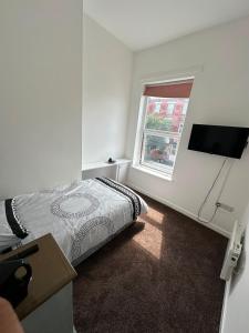 a white bedroom with a bed and a window at King Street Rooms in Liverpool