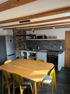 a kitchen with a wooden table and yellow chairs at Allgäuer Taucherhof in Aitrang