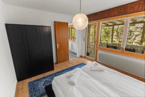 a bedroom with a bed and a large window at Logement spacieux et charmant in Nendaz