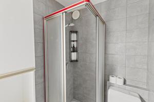 a shower with a glass door in a bathroom at Logement spacieux et charmant in Nendaz +38 photos