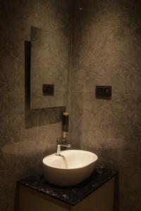 ein Badezimmer mit einem weißen Waschbecken und einem Spiegel in der Unterkunft Hotel Shellmark in Elivāla