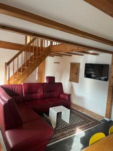 a living room with a red couch and a table at Allgäuer Taucherhof in Aitrang