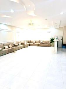 a living room with couches and a white floor at شاليهات حياة روز in Taif