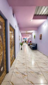 a hallway with a tile floor and purple walls at Hotel BABA DEEP SINGH RESTAURANT AND ROOMS in Ahmedabad
