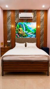 a bedroom with a bed with a painting on the wall at Hotel BABA DEEP SINGH RESTAURANT AND ROOMS in Ahmedabad
