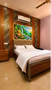 a bedroom with a bed with a painting on the wall at Hotel BABA DEEP SINGH RESTAURANT AND ROOMS in Ahmedabad